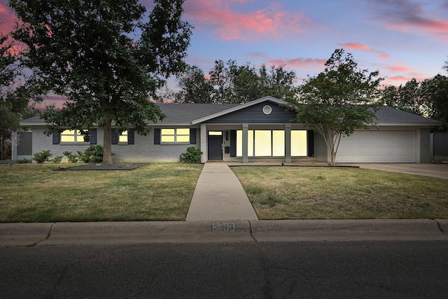 ranch-style house featuring concrete driveway, a front lawn, a porch, and a garage
