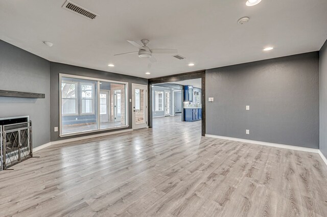 unfurnished living room with visible vents, baseboards, ceiling fan, and light wood-type flooring