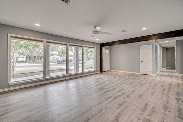 unfurnished living room with light wood-style floors, baseboards, a ceiling fan, and a wealth of natural light