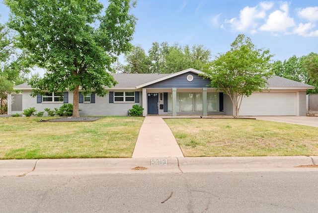 ranch-style home featuring a garage, covered porch, concrete driveway, and a front lawn