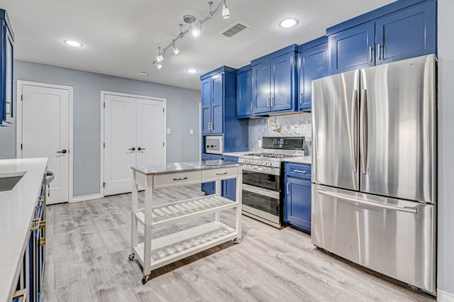 kitchen with visible vents, light countertops, light wood finished floors, appliances with stainless steel finishes, and blue cabinetry