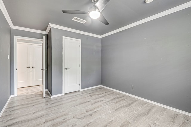 unfurnished bedroom with light wood-style floors, baseboards, ornamental molding, and visible vents