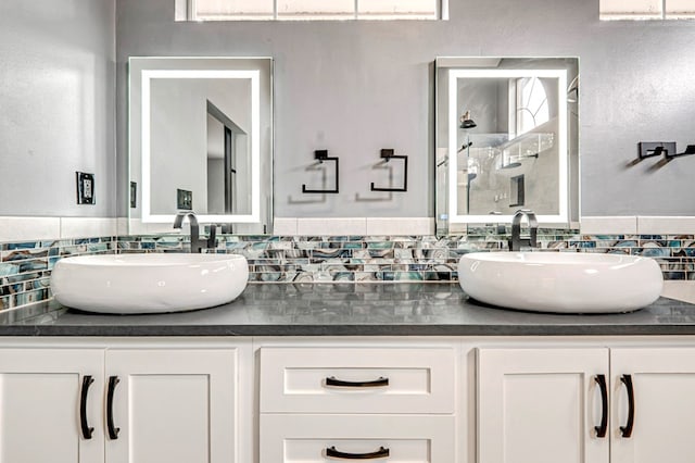 full bath featuring double vanity, a walk in shower, and a sink