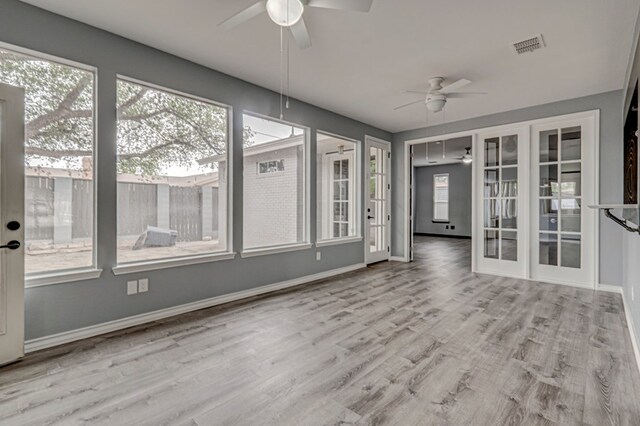 unfurnished sunroom featuring french doors, plenty of natural light, and visible vents