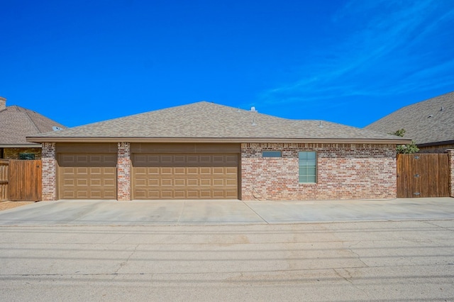 5319 Half Moon Cir, Midland, TX 79707 - view of front facade featuring concrete driveway, an attached garage, brick siding, fence, and roof with shingles