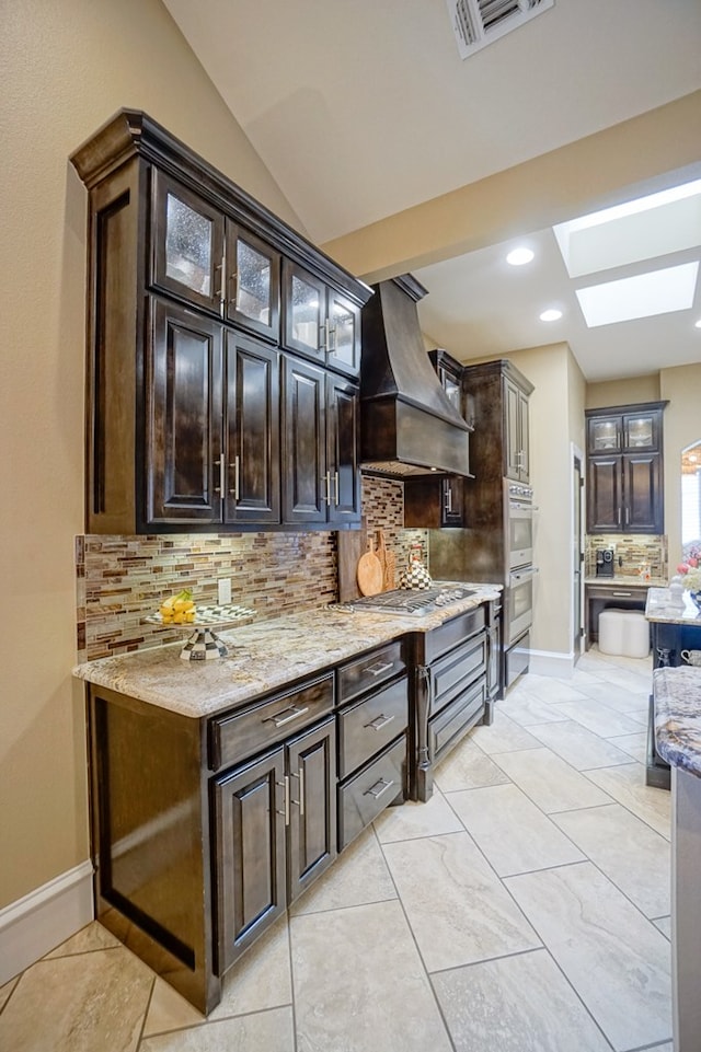 5319 Half Moon Cir, Midland, TX 79707 - bar area with custom range hood, a skylight, backsplash, appliances with stainless steel finishes, and recessed lighting