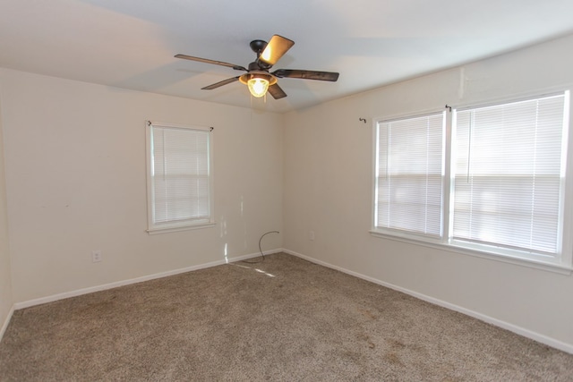 carpeted empty room featuring ceiling fan and a healthy amount of sunlight