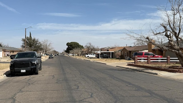 view of road featuring curbs, sidewalks, and a residential view