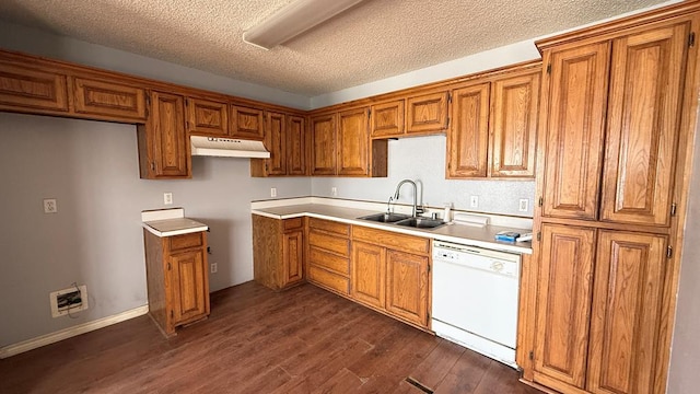 kitchen with brown cabinets, dishwasher, under cabinet range hood, and a sink