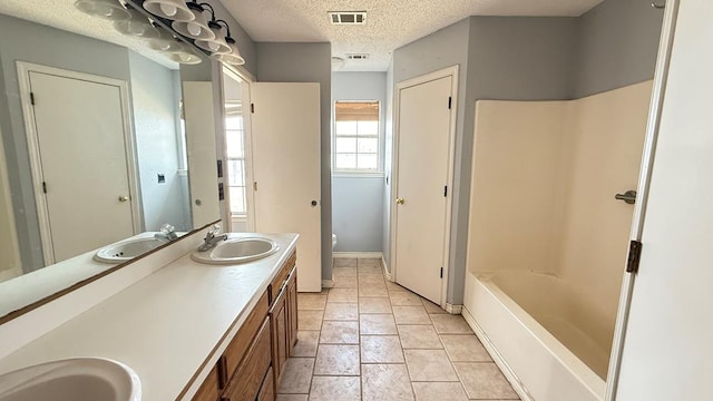 bathroom featuring visible vents, a sink, a textured ceiling, and toilet