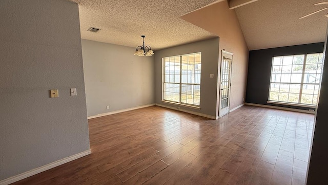 unfurnished room featuring dark wood-type flooring, visible vents, a textured ceiling, and baseboards