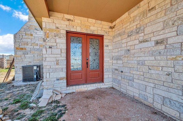 view of exterior entry with cooling unit and french doors