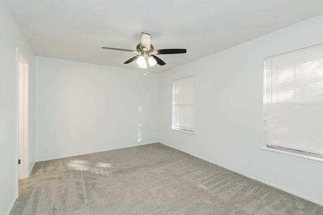 carpeted spare room featuring ceiling fan