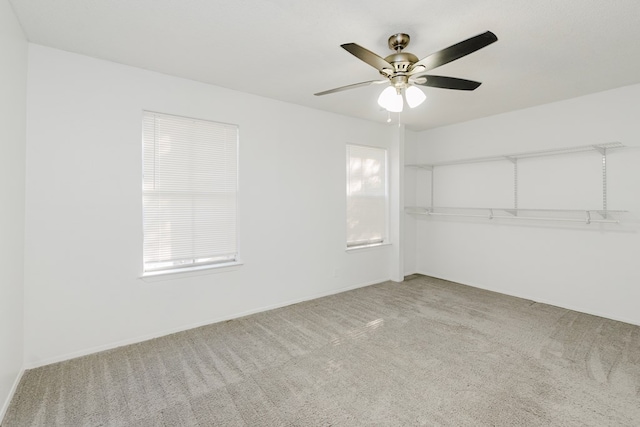 carpeted spare room featuring ceiling fan