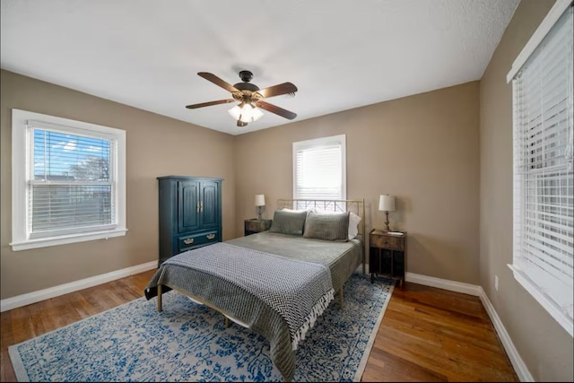 bedroom with ceiling fan, baseboards, and wood finished floors