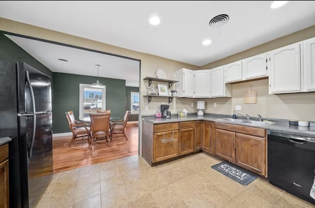 kitchen with visible vents, white cabinets, a sink, black appliances, and baseboards