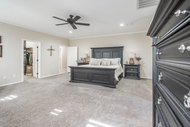 bedroom featuring ceiling fan, light colored carpet, ornamental molding, and a walk in closet