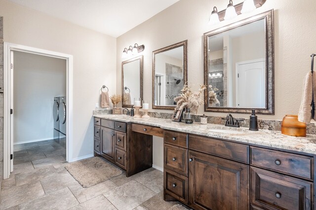 bathroom featuring vanity, washer and clothes dryer, and a shower