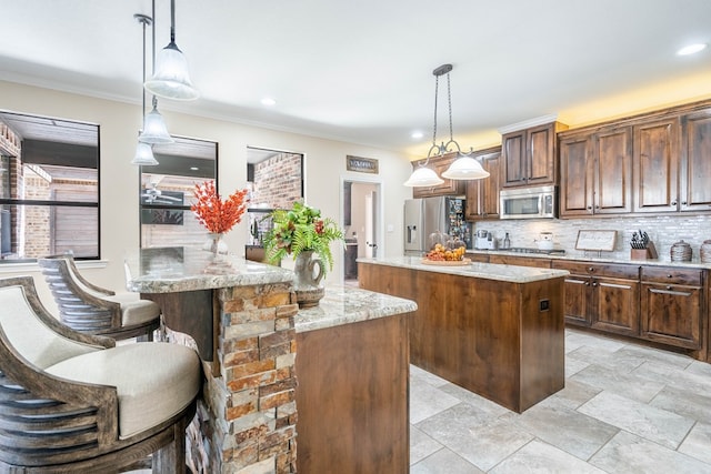 kitchen featuring decorative light fixtures, a center island, kitchen peninsula, and appliances with stainless steel finishes