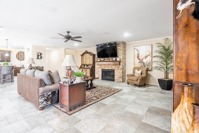 living room featuring crown molding, ceiling fan, and a fireplace