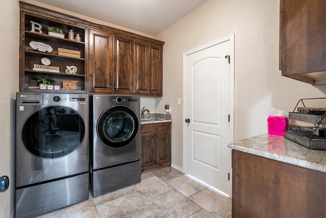 laundry area featuring cabinets, washer and clothes dryer, and sink