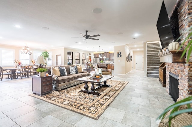 living room featuring ornamental molding and ceiling fan with notable chandelier