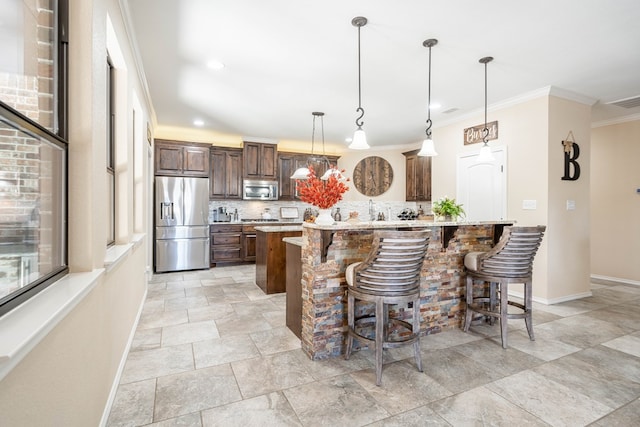 kitchen with appliances with stainless steel finishes, pendant lighting, a kitchen breakfast bar, decorative backsplash, and a center island