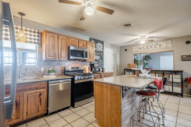 6308 S County Rd 1182, Midland, TX 79706 - kitchen with a sink, a ceiling fan, a breakfast bar area, appliances with stainless steel finishes, and visible vents