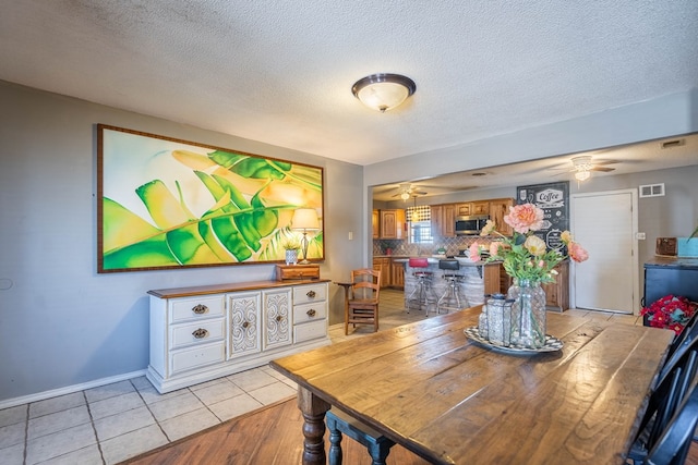 6308 S County Rd 1182, Midland, TX 79706 - dining space featuring light tile patterned flooring, a textured ceiling, visible vents, baseboards, and ceiling fan