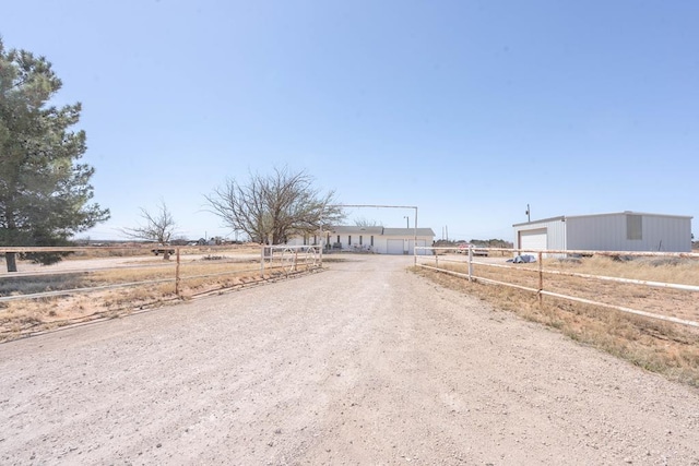 6308 S County Rd 1182, Midland, TX 79706 - view of road featuring dirt driveway, an outbuilding, a rural view, and a gated entry