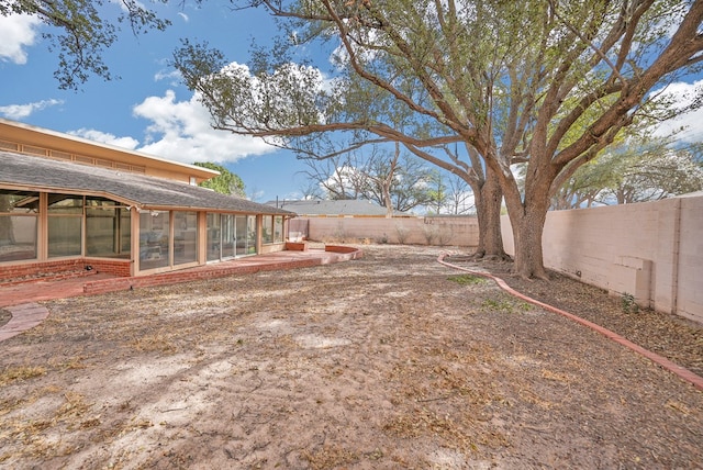 view of yard with a fenced backyard and a sunroom