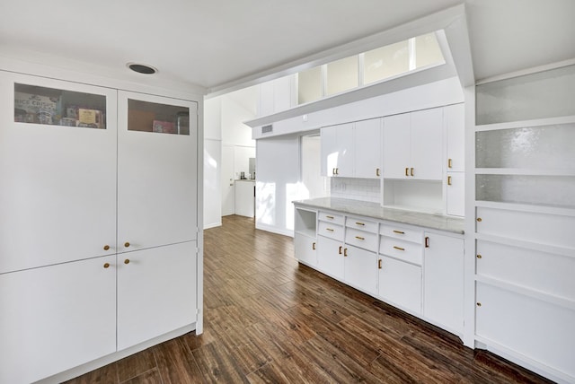 kitchen featuring dark wood-style floors, light stone counters, backsplash, glass insert cabinets, and white cabinetry