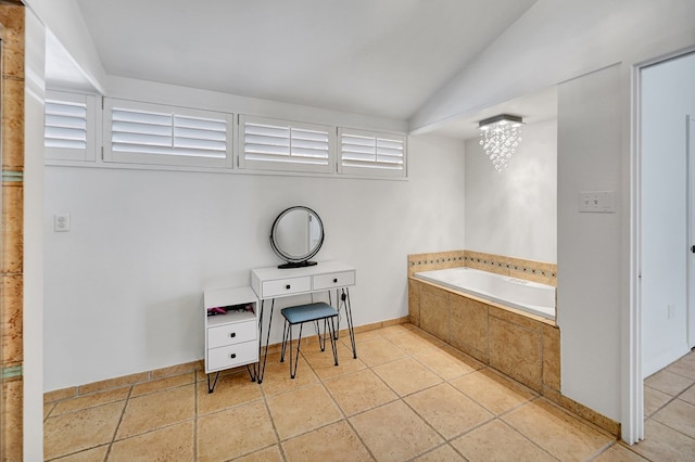 full bath with lofted ceiling, baseboards, and a bath