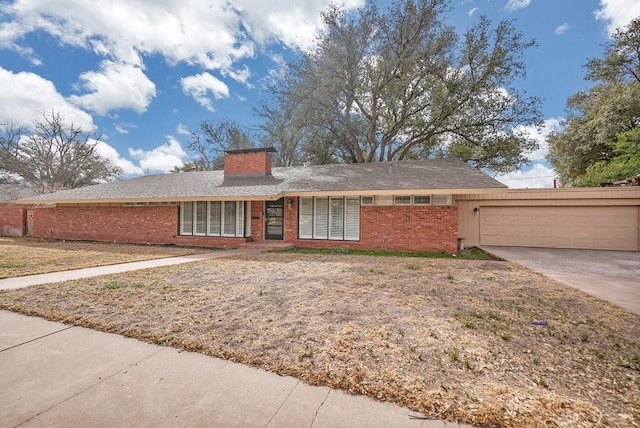 ranch-style house with driveway, brick siding, a chimney, and an attached garage