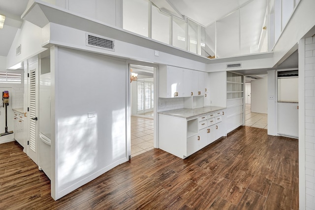 kitchen with visible vents, white cabinets, and dark wood-type flooring