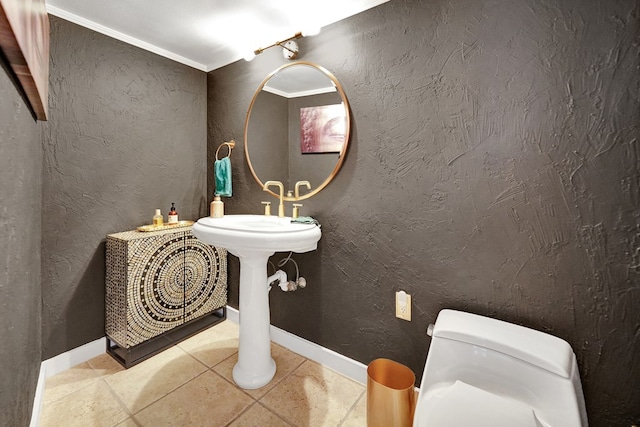 half bath with a textured wall, toilet, ornamental molding, baseboards, and tile patterned floors