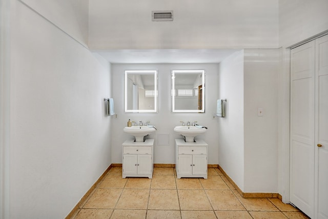 bathroom with a sink, visible vents, and baseboards