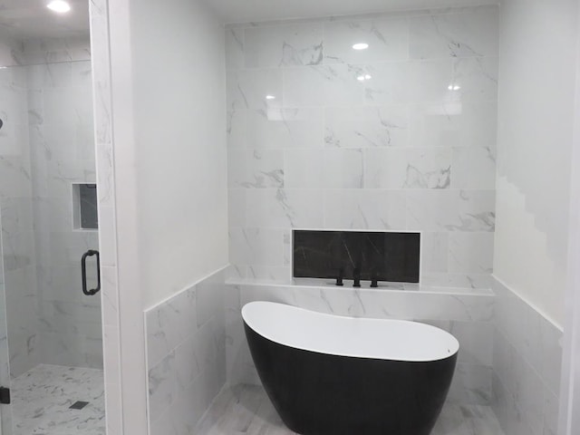 bathroom featuring tile walls and plus walk in shower