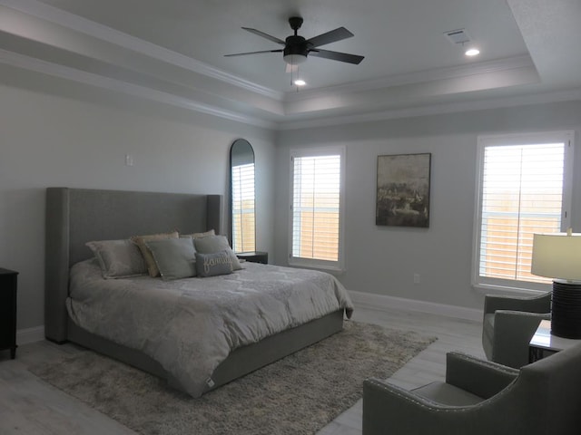 bedroom with a raised ceiling, ceiling fan, crown molding, and light hardwood / wood-style floors