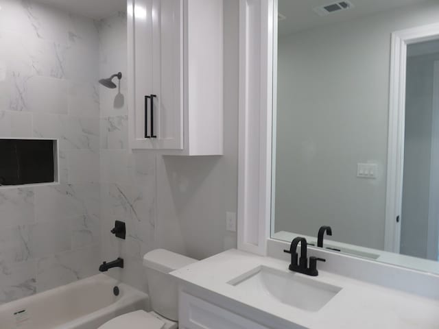 full bathroom with toilet, vanity, and tiled shower / bath