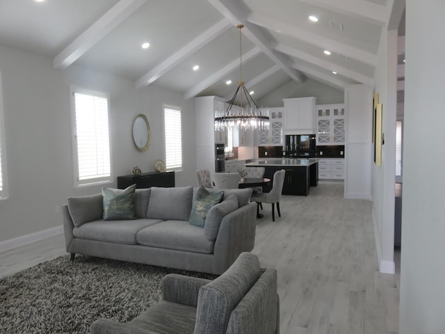 living room featuring a chandelier, vaulted ceiling with beams, and light wood-type flooring