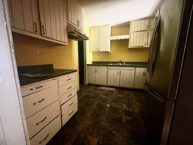 kitchen featuring cream cabinetry, stainless steel fridge, and sink