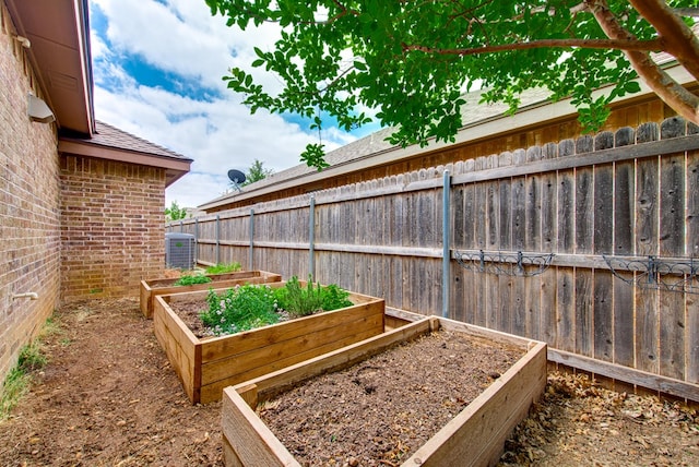 view of yard with central AC, fence, and a vegetable garden