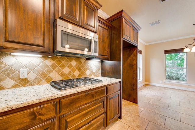 kitchen with stainless steel appliances, backsplash, baseboards, visible vents, and crown molding