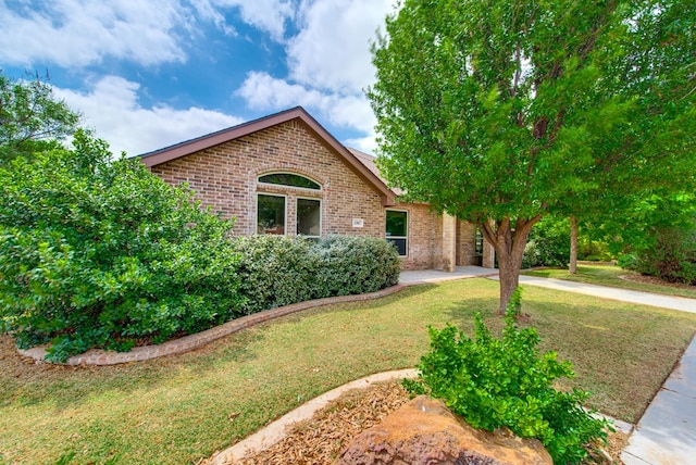 view of front of house featuring brick siding and a front lawn