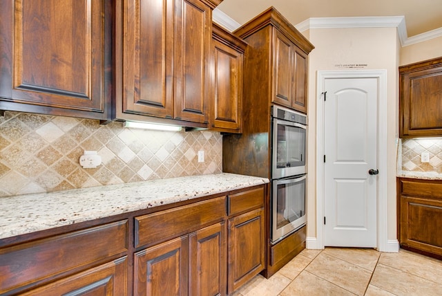 kitchen with ornamental molding, light stone counters, decorative backsplash, and double oven