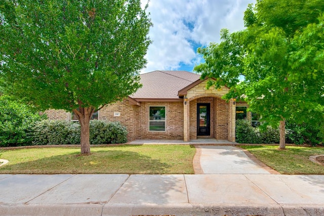 view of front of house with a front yard and brick siding