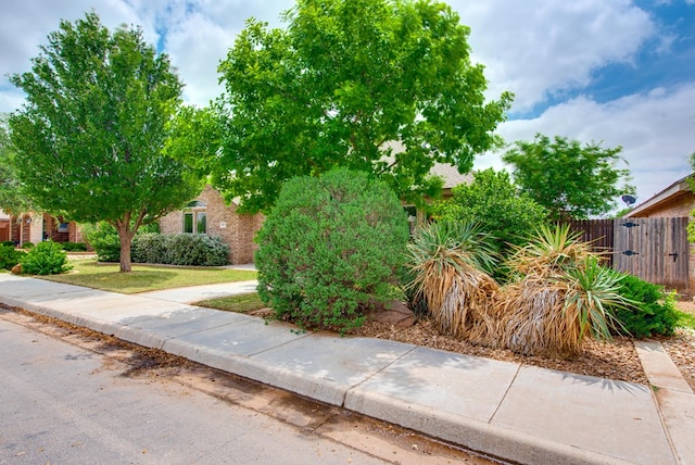 view of front of house featuring brick siding and fence