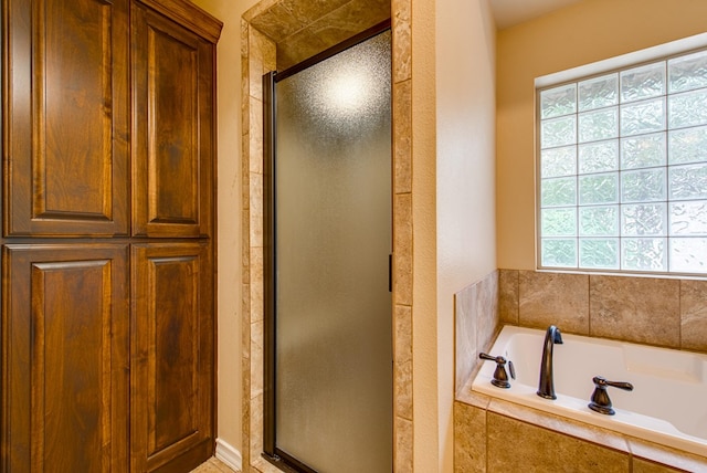 full bathroom with a garden tub and a shower stall