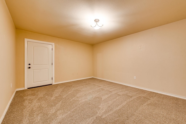 unfurnished room featuring carpet and baseboards